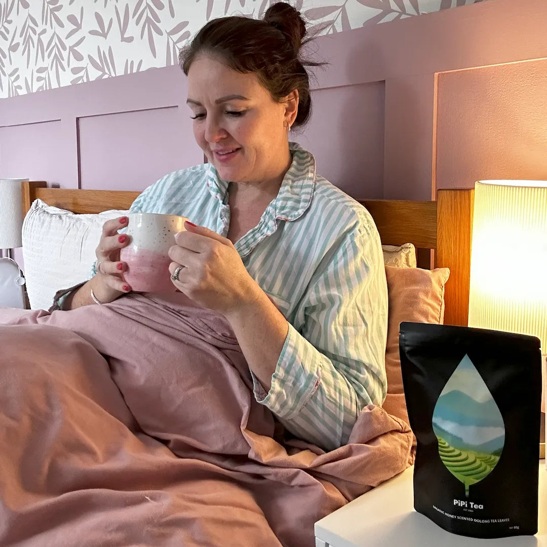 Woman enjoying PiPi Tea in bed